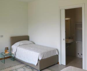 ein Schlafzimmer mit einem Bett und einer Tür zu einem Bad in der Unterkunft Porta Baciamano in Geraci Siculo