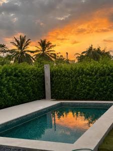 a swimming pool with a sunset in the background at Casa Tierra Esmeralda in Parrita
