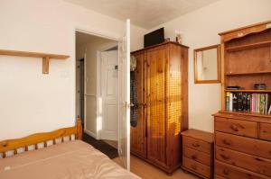 a bedroom with a bed and a dresser at Single Room with shared bathroom in Cheshunt
