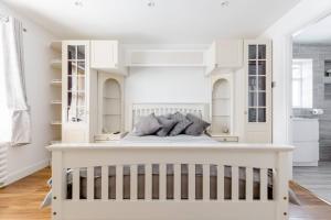 a white bedroom with a bed and white cabinets at Single Room with shared bathroom in Cheshunt