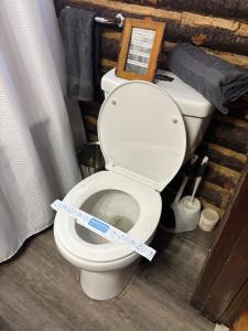 a bathroom with a toilet with a measuring tape on it at The Rustic Cabin in Blakeslee +39 photos