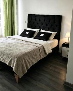 a bedroom with a large bed with two pillows at Departamento Centro Iquique in Iquique