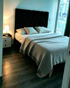a bedroom with a large bed with a large window at Departamento Centro Iquique in Iquique
