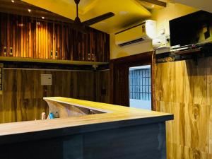 a kitchen with a counter top in a room with wooden walls at Vijay residency TVR in ThiruvÄrÅ«r +4 photos
