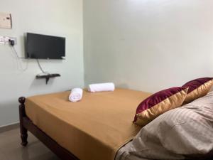 a bedroom with a bed with a tv on the wall at Vijay residency TVR in ThiruvÄrÅ«r