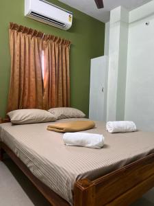 a bedroom with a bed with two towels on it at Vijay residency TVR in ThiruvÄrÅ«r