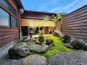 a garden with rocks and a fountain next to a house at 龍助25 Ryusuke25 in Komatsu