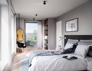 um quarto com uma grande cama branca e uma cadeira em Bett&Bude Boardinghouse em Westerland