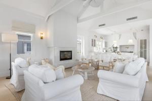 a white living room with white chairs and a fireplace at Farmhouse Hunter Valley in Pokolbin