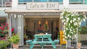 a blue picnic table in a coffee shop with a sign at Yangyang Bono Pet-friendly Pension in Yangyang +1 photo
