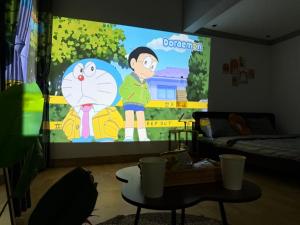 a room with a large screen with a cartoon at Muối Vừng Home in Ða Gia