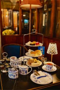 a table with plates of food and cups on it at Victorian Loft Living Hotel 22 in London