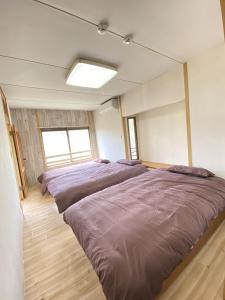 a bedroom with three beds in it at トラストメゾン荻 in Ito