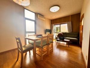 a living room with a table and chairs and a couch at トラストメゾン荻 in Ito +7 photos