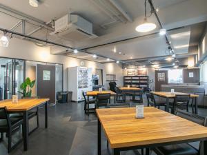ein Esszimmer mit Holztischen und Stühlen in der Unterkunft HOTEL Calmplace in Kanda