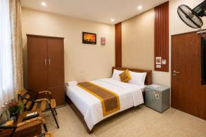 a hotel room with a bed and a chair at Bảo Ngọc Cô Tô hotel in Đảo Cô Tô