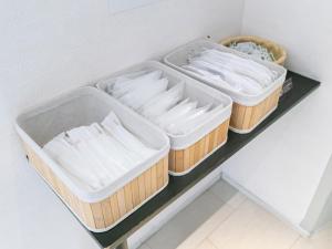 Drei Tabletts mit weißen Handtüchern auf einem Regal in der Unterkunft HOTEL Calmplace in Kanda + 42 Fotos