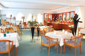 a restaurant with white tables and chairs and a counter at Pension Rabennest, Flexibler Selbst-Check-In, Keine Rezeption in Raben Steinfeld