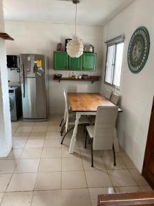 a kitchen with a wooden table and a refrigerator at Casa para 6 personas con vista al mar Cumbre del Diablo 3 in Punta Del Diablo +20 photos