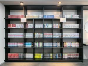 ein Regal voller Bücher in einem Zimmer in der Unterkunft HOTEL Calmplace in Kanda