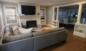 a living room with a couch and a fireplace at Middletown Bungalow w/Hot Tub and Private Yard - RIBryan Properties in Middletown