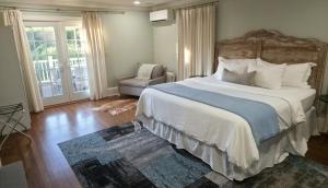 a bedroom with a large bed and a chair at Middletown Bungalow w/Hot Tub and Private Yard - RIBryan Properties in Middletown
