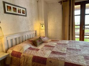 a bedroom with a bed with a quilt on it at Brisas del Diablo 1 in Punta Del Diablo