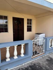 a house with a blue railing and a door at Little Escape in The Lime