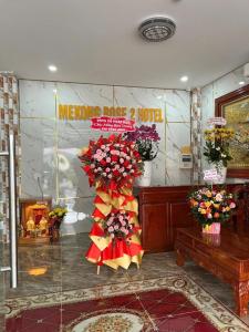 a lobby with flowers and a sign in a room at Mekong Rose 2 in Bình Thủy