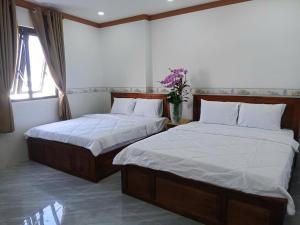 two twin beds in a room with two windows at Mekong Rose 2 in Bình Thủy