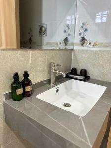 a bathroom counter with a white sink and a mirror at Mekong Rose 2 in Bình Thủy +27 photos