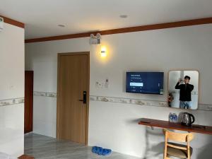 a man standing in a room with a tv on the wall at Mekong Rose 2 in Bình Thủy