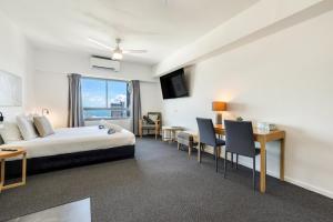a hotel room with a bed and a table and chairs at 15th Floor Superior Hotel Suite King Bed in Darwin