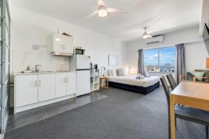 a hotel room with a bed and a table and a kitchen at 15th Floor Superior Hotel Suite King Bed in Darwin