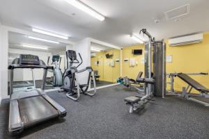 a gym with several treadmills and machines in a room at 15th Floor Superior Hotel Suite King Bed in Darwin