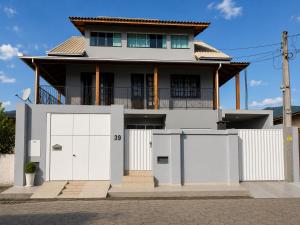 a white house with two white garage doors at Casa ao lado do parque Beto carreiro da de ir a pé para o parque João carlos casas in Penha