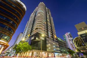 a tall building in a city at night at 15th Floor Superior Hotel Suite King Bed in Darwin