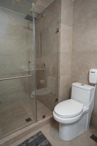 a bathroom with a toilet and a glass shower at 1503 A - INARA Downtown Four in Guatemala +14 photos