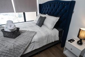 a bedroom with a large bed with a blue headboard at 1503 A - INARA Downtown Four in Guatemala