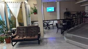 eine Lobby mit Sofa, Tisch und Stühlen in der Unterkunft Bahia Ourense Hotel in San Clemente del Tuyú