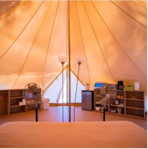 a room with a tent with two fans in it at GuanaGlamp in Tamarindo