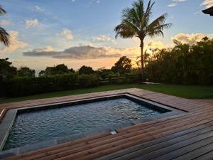 a swimming pool in a backyard with a wooden deck at Chalet vue mer, piscine in Saint-Claude