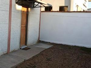 a garage with a white wall and a door at República Nunes e Silva in Vilhena