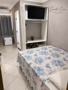 a bedroom with a bed and a flat screen tv at Hotel Pousada Santa Ceia in Aparecida