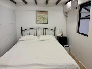 a white bed in a white bedroom with a window at Duplex Garden Villa with Private Courtyard Jing'an Villa Near Metro Downtown Shanghai in Shanghai
