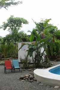 two chairs sitting next to a swimming pool at TULIN AZUL -Cabina familiar con piscina y cocina equipada, cerca de Jaco- in Tulín