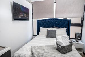 a bed with a blue headboard in a bedroom at Ceiling INARA 1503 B in Guatemala