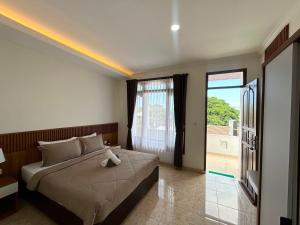 a bedroom with a bed and a large window at Pantai Ayu Homestay in Padangbai +16 photos