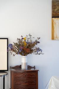 a vase of flowers sitting on top of a dresser at Homenest in Gledswood Hills