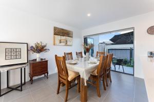 a dining room with a table and chairs at Homenest in Gledswood Hills +7 photos